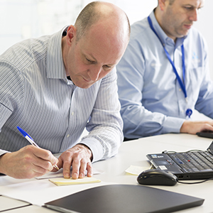 Male office worker writing down notes